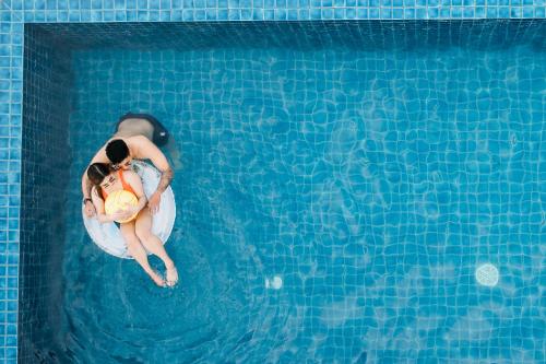 a man and woman floating in a swimming pool at Zuri Hotel in Iloilo City