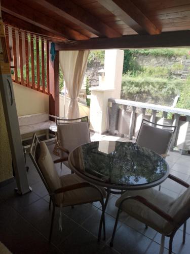 a glass table and chairs on a balcony at Rab-centar in Rab