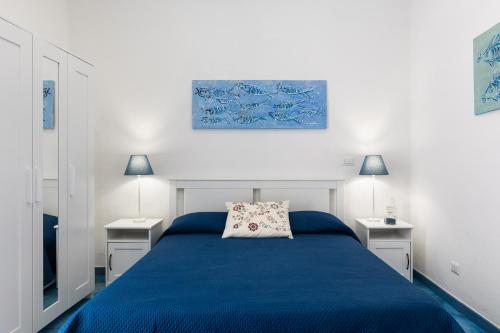 een slaapkamer met een blauw bed en 2 nachtkastjes bij La cianciola in Gaeta