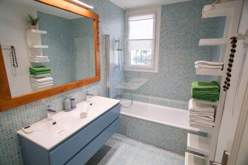 une salle de bain avec un lavabo, une baignoire et un miroir dans l'établissement Villa NOSSÌ BÈ, à Carqueiranne