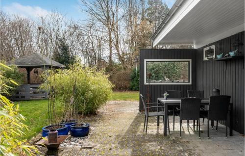 a patio with a table and chairs in a backyard at 3 Bedroom Gorgeous Home In Gilleleje in Gilleleje