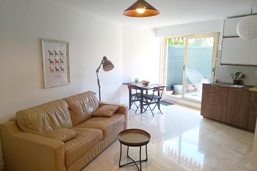 un salon avec un canapé et une table dans l'établissement Refurbished apartment with terrace and garden, à Nice