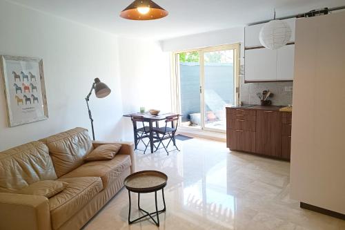 un salon avec un canapé et une table et une cuisine dans l'établissement Refurbished apartment with terrace and garden, à Nice