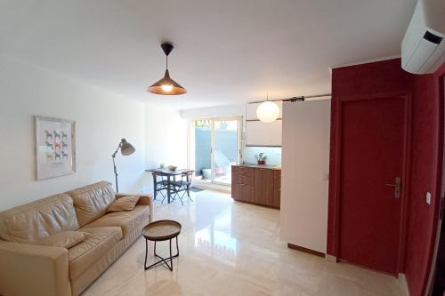 un salon avec un canapé et une table dans l'établissement Refurbished apartment with terrace and garden, à Nice