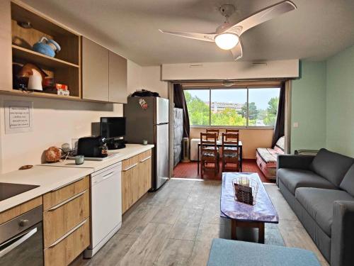 une cuisine et un salon avec un canapé et une table dans l'établissement Chez Clo! Studio tout équipé jusqu'à 4 personnes, à Port-la-Nouvelle