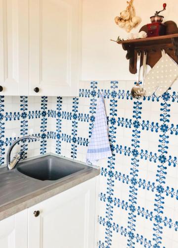 a kitchen with a sink and blue and white tiles at Torre - Haus mit Dachterrasse in Capoliveri