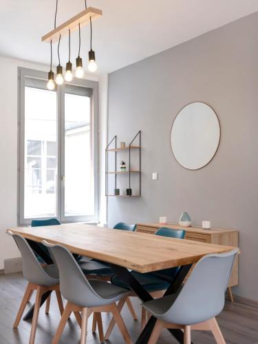 une salle à manger avec une table et des chaises en bois dans l'établissement Le Havre Nancéien, à Nancy