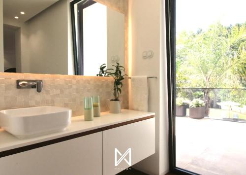 a bathroom with a sink and a mirror and a window at MyStay - Casa 134 in Ribeirão