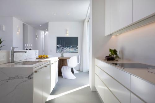 a white kitchen with white counters and white cabinets at Big Blue Villas in Santa Maria