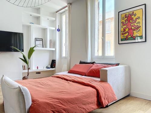 - une chambre avec un lit doté de draps rouges et une fenêtre dans l'établissement Appartement Lumineux - Vue Notre-Dame de la Garde - Les Frères de la Loc', à Marseille