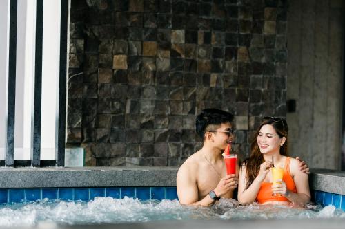 a man and a woman sitting in a swimming pool at Zuri Hotel in Iloilo City