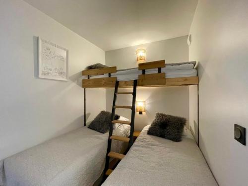 - 2 lits superposés dans une petite chambre avec des lits blancs dans l'établissement Homency - Résidence Fermes de l'Alpe D102, à L'Alpe-d'Huez