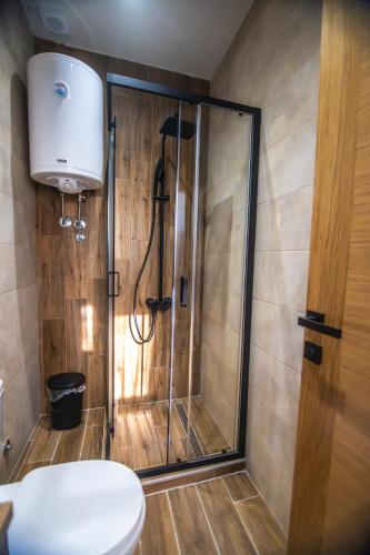 a shower stall in a bathroom with a toilet at Apartmani Monero in Vrnjačka Banja