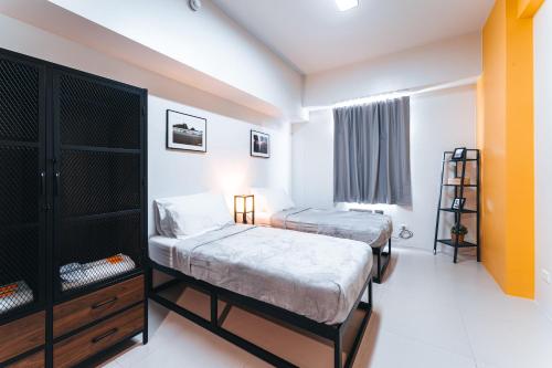 a bedroom with two beds and a window at The City Flats Circuit in Manila