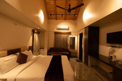 a hotel room with a bed and a television at Freesia Resort by Express Inn in Nashik