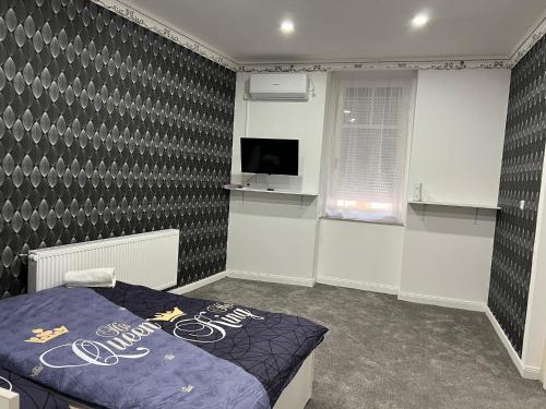 a bedroom with a bed and a tv in it at Adél Apartman in Kisújszállás