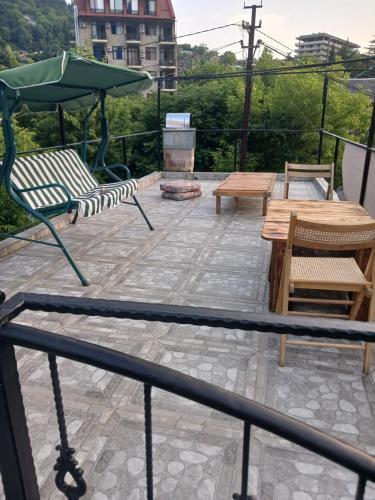 a patio with a table and benches and an umbrella at DATI in Borjomi
