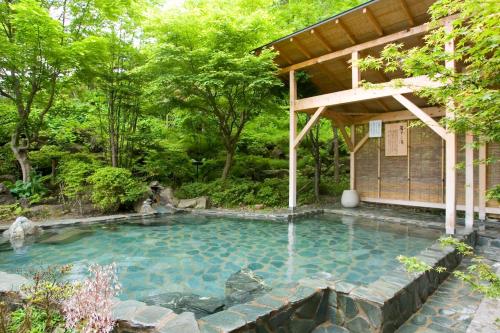 una piscina en un jardín con un pabellón en Hotel Taikan, en Morioka