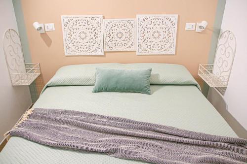 1 dormitorio con 1 cama con almohada verde en La Vispa Teresa Almalusa Apulian home by In Puglia service, en Martina Franca