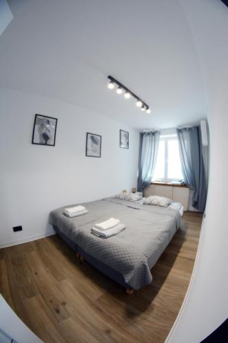 a large bed in a white room with a mirror at Apartament Młyńska 26 in Augustów
