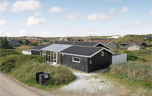 a black house on the side of a dirt road at Holiday Home Baunebjergvej Sande V H in Havrvig