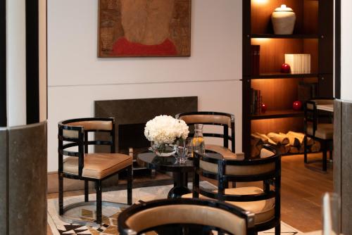a dining room with a table and chairs and a fireplace at Grand Hôtel Champs-Elysées in Paris