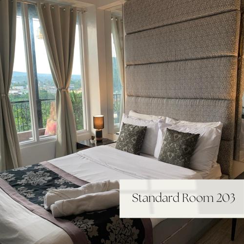a bedroom with a large bed with a large window at Alta Residences in Daraga