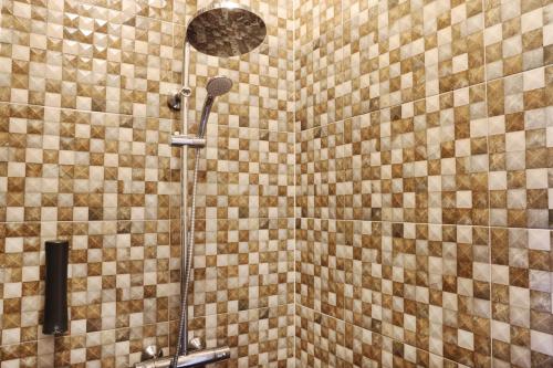 um chuveiro na casa de banho com uma parede em azulejo em Fosshotel Hellnar em Hellnar