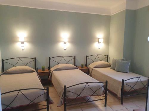 two beds in a room with lights on the wall at Filoxenia Hotel in Chios