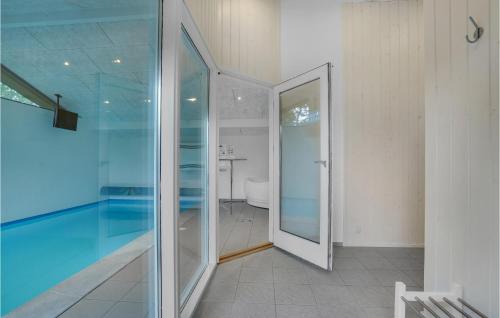 a glass door leading to a bathroom with a tub at Cozy Home In Hjørring With Sauna in Lønstrup