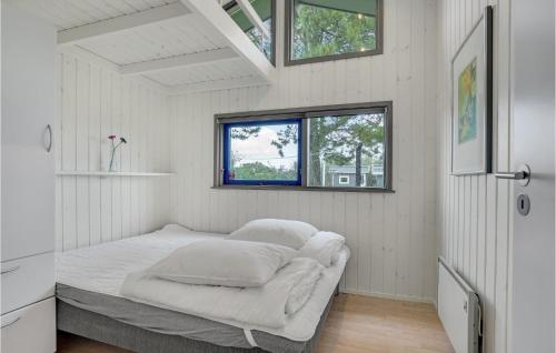 a bedroom with a bed in a room with windows at Cozy Home In Hjørring With Sauna in Lønstrup