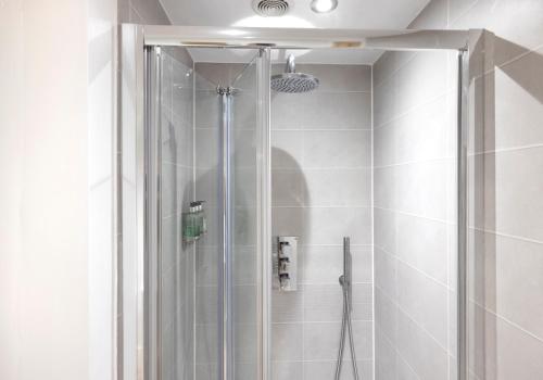 a shower with a glass door in a bathroom at Aurora House Hot Tub & Sea View in Buckie