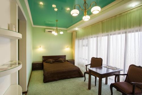 a bedroom with a bed and a table and chairs at Hotel Zolotoy Globus in Pyatigorsk
