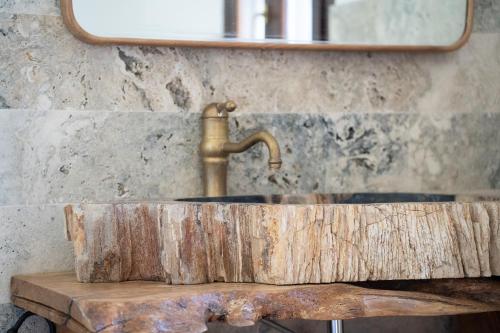 un lavandino del bagno fatto da un tronco con un rubinetto di Villa Castrignano a Monopoli
