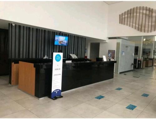 an airport lobby with a reception desk and a sign at Recife Infinity Pool - VIP in Recife