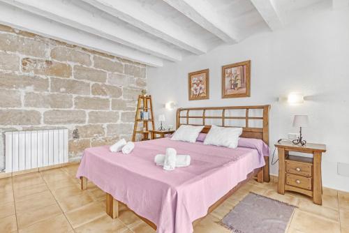 Un dormitorio con una cama grande y una pared de ladrillo. en Finca Son Sanxo, en Alaior