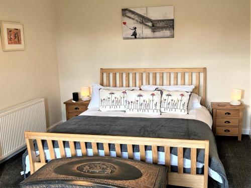Un dormitorio con una cama grande con cabecero de madera. en Aultnagar, en Kirkton of Largo