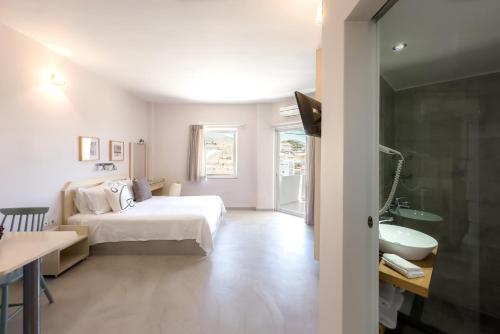 a bedroom with a bed and a sink and a tub at Karystos Mare Apartments in Karistos
