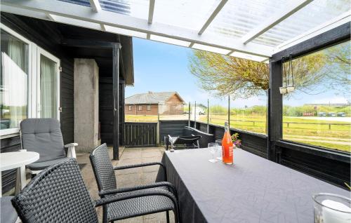 a patio with a table and chairs on a balcony at Two-Bedroom Holiday Home With A Fireplace In Rømø in Bolilmark
