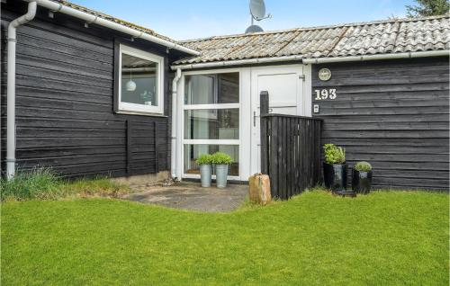 a black house with a white door and a yard at Two-Bedroom Holiday Home With A Fireplace In Rømø in Bolilmark