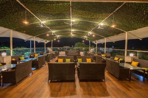 a restaurant with tables and chairs on a wooden floor at Freesia Resort by Express Inn in Nashik