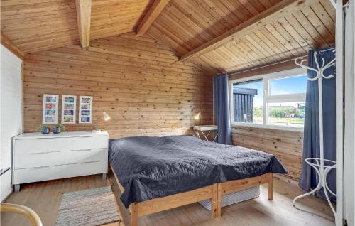 a bedroom with a bed and a wooden wall at Two-Bedroom Holiday Home With A Fireplace In Rømø in Bolilmark