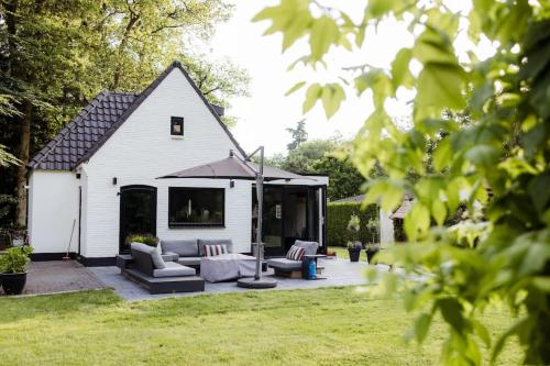 a white shed with a couch and chairs in a yard at Het Goede Gemoed in Enschede
