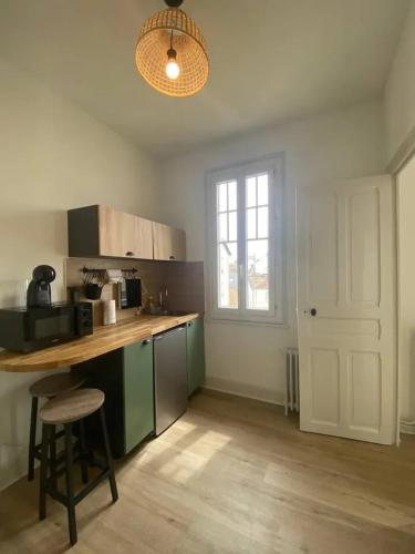 une cuisine avec un comptoir, une table et une fenêtre dans l'établissement Charmant appartement à Vichy 21 m² avec balcon et vue sur la ville, à Vichy