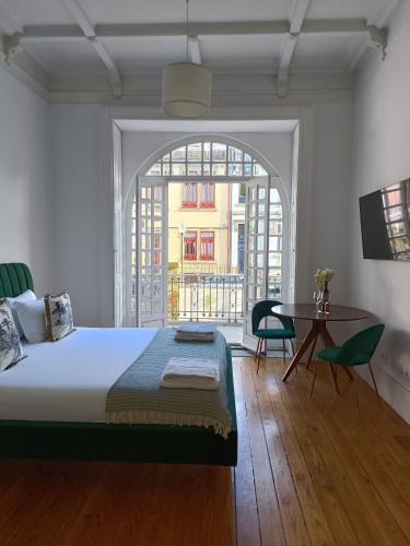 a bedroom with a bed and a table and a window at Casa D'Almeida by Porto Stories in Porto