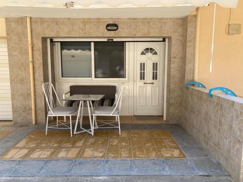 a patio with a table and chairs next to a door at Dims Studio Paralia Ofryniou in Ofrínion