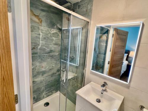 un baño con ducha y lavabo en The Swallow's Nest, en Dingle