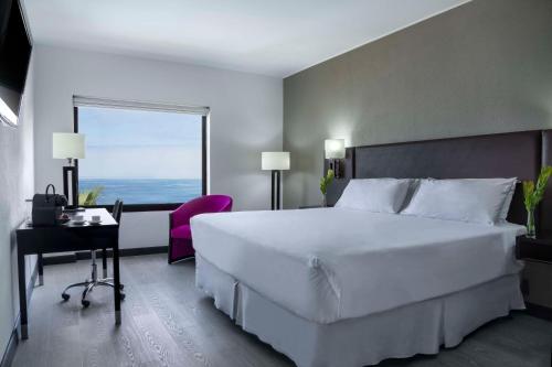 Una cama o camas en una habitación de NH Iquique Costa