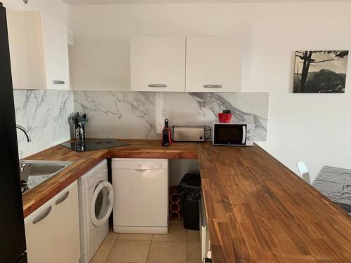 une cuisine avec des armoires blanches et un comptoir dans l'établissement Appartement T3 Vue mer, à Conca