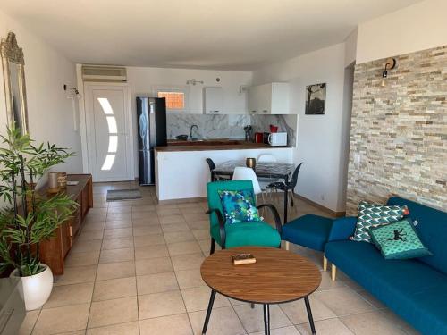 un salon avec un canapé bleu et une cuisine dans l'établissement Appartement T3 Vue mer, à Conca